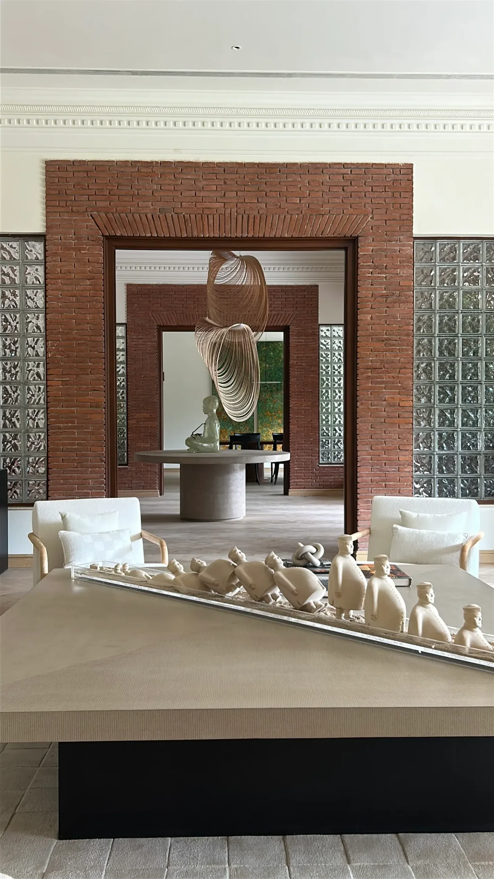 Brick portal with figurines and a wire pendant at the Delhi farmhouse by Sonia Gehlot