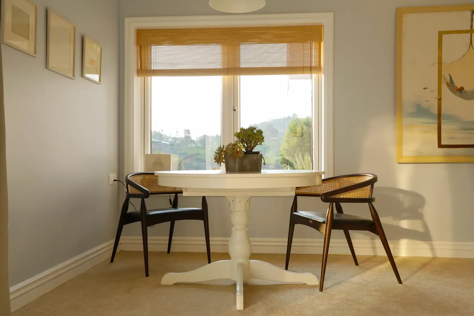 Breakfast table and cane chairs by the window at Coonoor by Sonia Gehlot