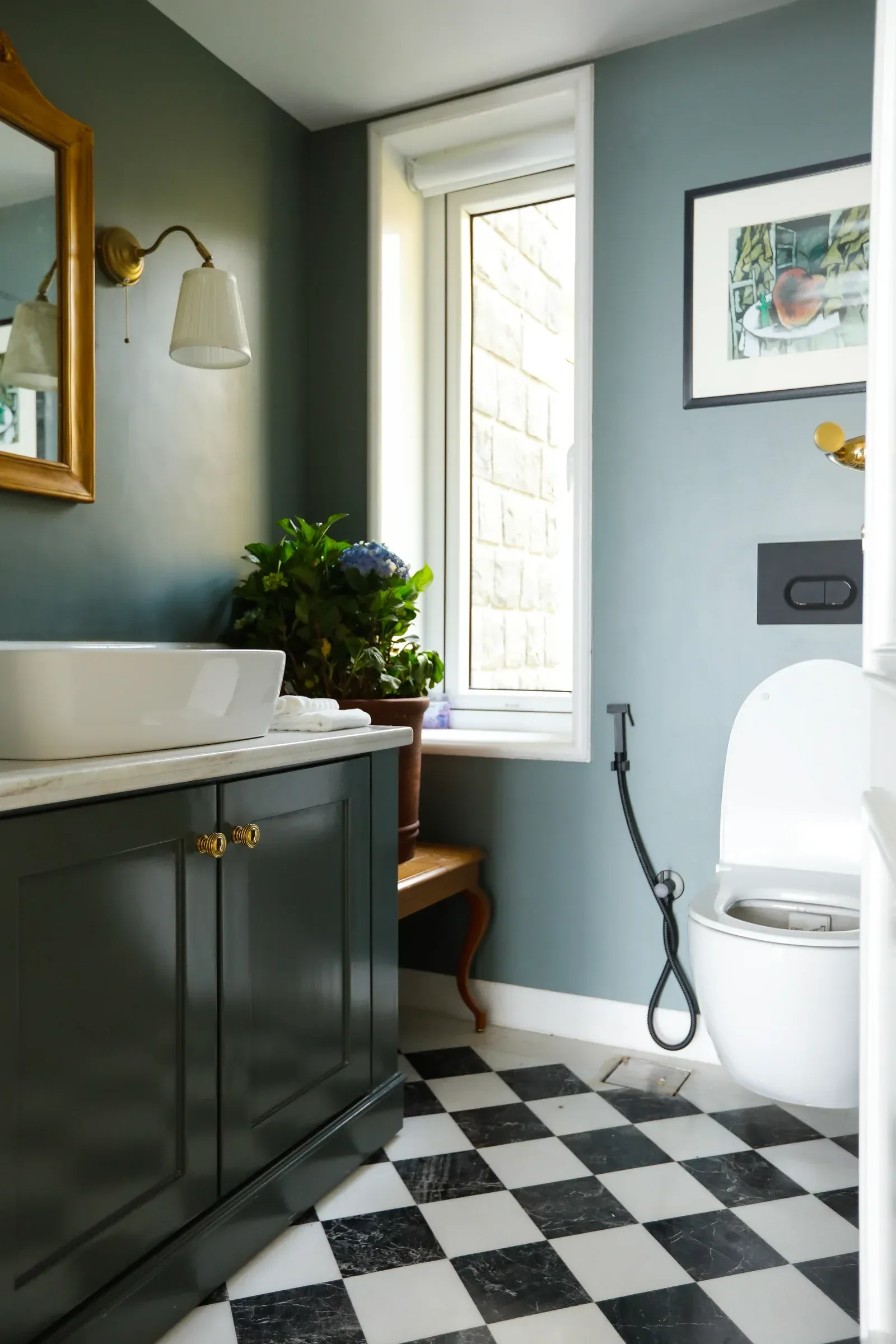 A green vanity with brass fittings and a chequered floor by Sonia Gehlot
